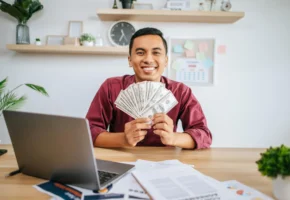 Person earning money online free from home using laptop with cash symbols representing online income opportunities