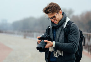 Photographer reviewing camera to sell photos online for passive income