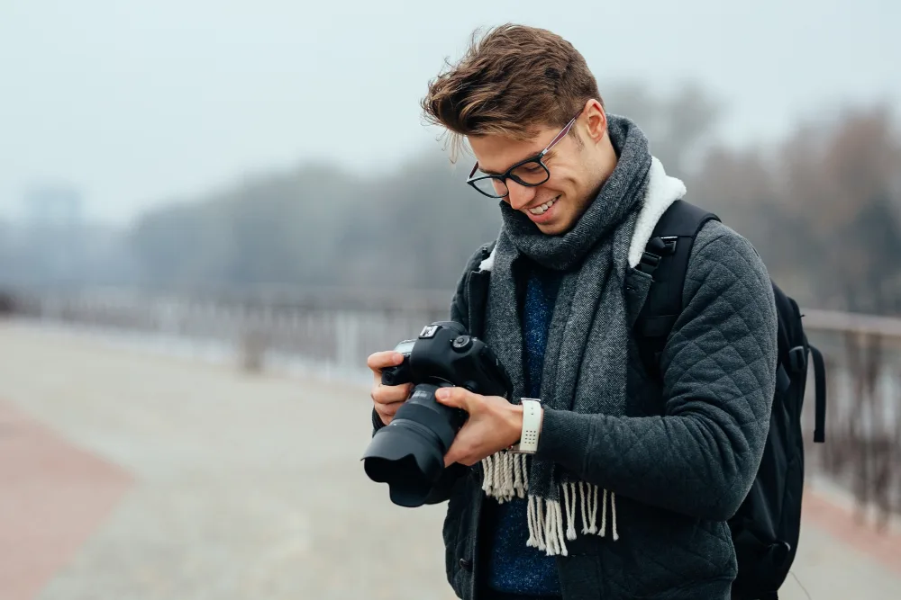 Photographer reviewing camera to sell photos online for passive income